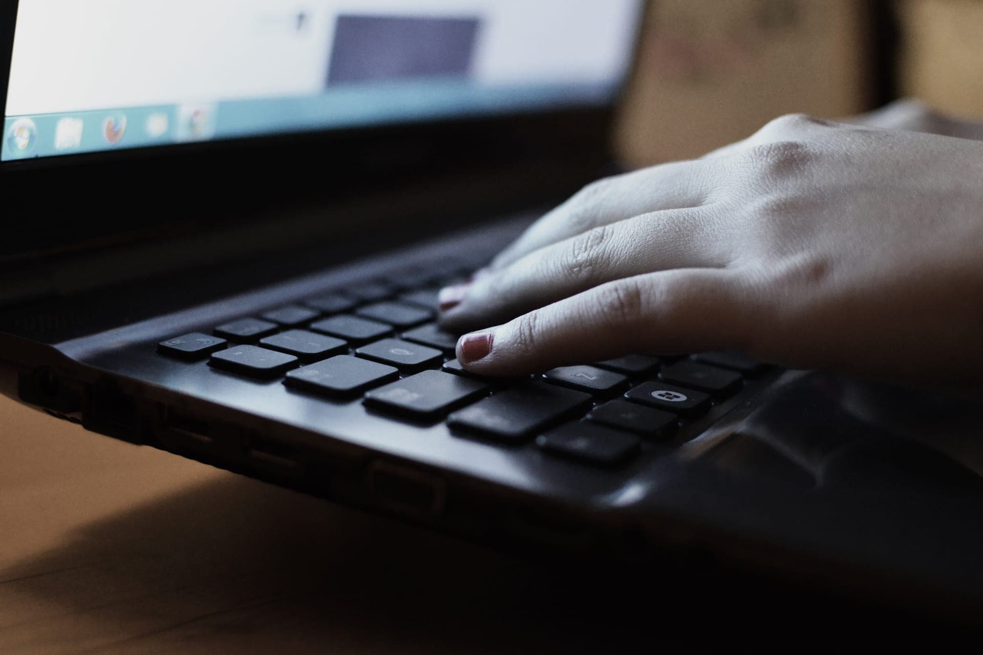 Hand typing on a laptop keyboard